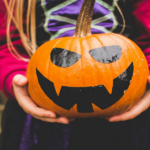 girl holding jack-o-lantern