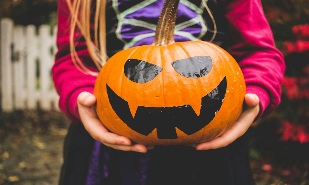 girl holding jack-o-lantern