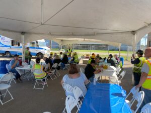 groups of people sitting around tables listening to speaker